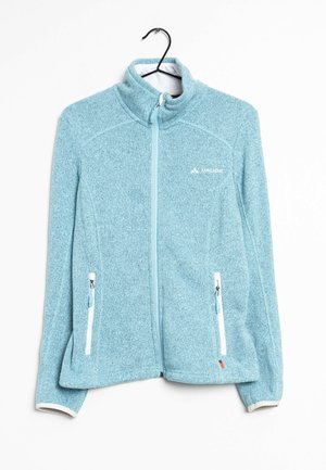 Light blue full-zip fleece jacket with high collar, two zippered white-trim pockets, and small logo on chest, hanging on black hanger.