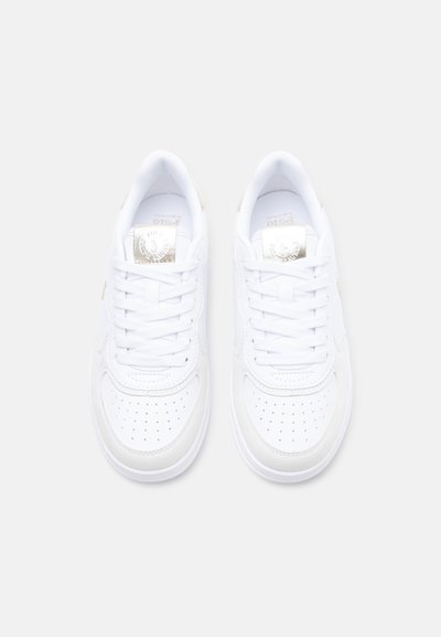 Ζευγάρι λευκά αθλητικά παπούτσια χαμηλού ύψους με διάτρητες άκρες και λευκά κορδόνια, σε θέα από πάνω σε απλό φόντο.