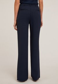 Pantalons ajustés marine avec une coupe droite, en tissu doux, deux poches arrière et des détails de couture subtils.