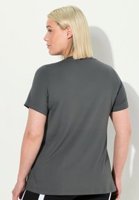 Grijze t-shirt met korte mouwen, een soepele structuur en ronde hals, met een relaxte pasvorm en minimale stiksel-details op de achterkant.