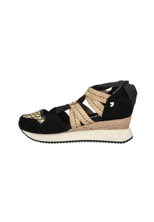 Zapatilla de cuña negra con correas tejidas beige, lazos de cinta negra, puntera dorada con diseño y suela intermedia texturizada sobre fondo blanco.