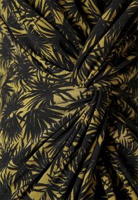 Tecido preto e amarelo com um padrão de folha de palma, apresentando pregas e um design torcido para textura; material macio e leve.