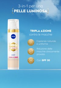 Fialo di NIVEA Luminous 630 anti-macchia in una bottiglia trasparente con un erogatore dorato. Formula di colore crema chiara, etichettata per una protezione SPF 30.