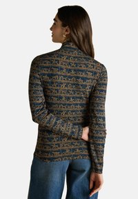 Długi rękaw w granatowym materiale z złotym wzorem przedstawiającym historyczne sceny, dopasowany krój z wysokim kołnierzem i wąskimi rękawami.