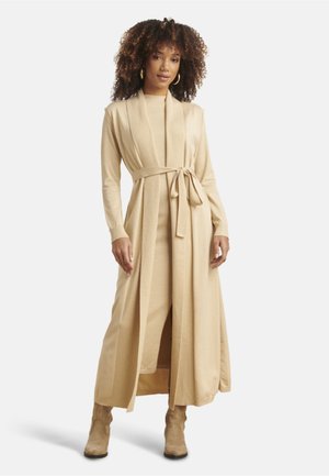 Beige dress and long cardigan set with a tie belt, featuring long sleeves, a smooth texture, and a floor-length design.