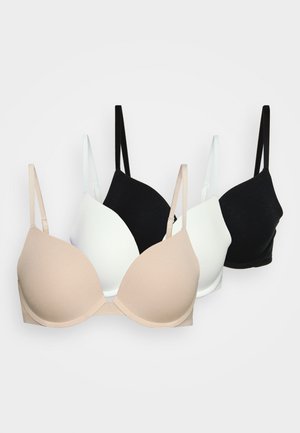 Three bras in beige, white, and black colors. Each features a smooth, molded cup design and thin adjustable straps. Soft, stretchy fabric.