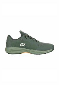 Green athletic shoe with a textured upper, reinforced sides, and orange accent on the sole. Features flat laces and a cushioned sole.