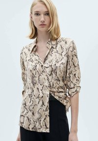 Beige slangenpatroon blouse met een kraag, lange mouwen opgerold, textuurstof en een rechte snit met een zijslit.