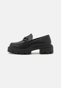 Schwarze Lederloafers mit einer kräftigen Profilsohle, ausgestattet mit einem dekorativen Riemen und runder Zehenpartie. Glatte Textur mit Steppdetails.