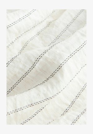 Gros plan sur un tissu blanc doux avec des fines rayures verticales noires cousues uniformément espacées et une surface texturée.