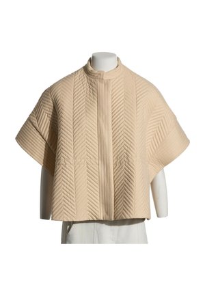 Chaqueta beige acolchada de manga corta con costuras en forma de chevron y cuello de pie sobre un torso de maniquí blanco.