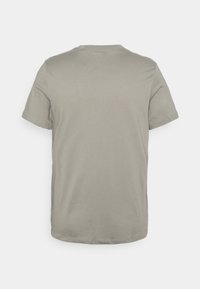 Camiseta de algodón gris con cuello redondo y mangas cortas, con un diseño liso y textura suave, sin logotipos ni patrones visibles.