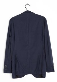 Mörkblå blazer hängande på en krok, med en slät tygkonstruktion, slag och knäppta manschetter med fyra knappar på varje ärm.