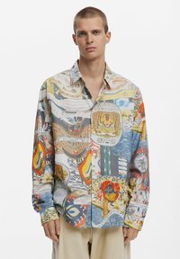 Button-up shirt made of lightweight fabric, featuring a colorful collage of graphic prints, including animals and abstract patterns.