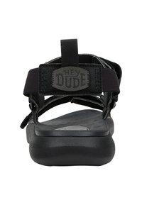 Sandalo nero con una soletta liscia, cinturini in nylon e tallone posteriore imbottito. Presenta una toppa quadrata con il logo sul cinturino.