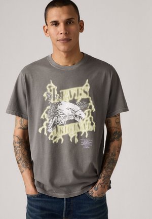 Grijze t-shirt met een grafisch ontwerp van een arend en de tekst "LEVIS ORIGINAL" in vet geel. Korte mouwen, van katoen, casual fit.