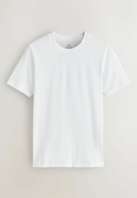 Vienkārša balta īsroku T-krekls ar apaļu kakla izgriezumu, vidēja izmēra ar zīmi "muskuļu fit", nosaukts un izklāts uz gaisīgas virsmas.