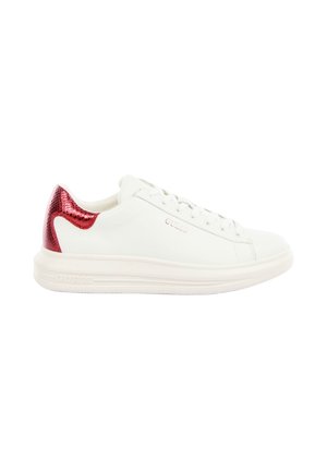 Baskets basses blanches avec talon métallique rouge, fermeture à lacets à l’avant et semelle blanche épaisse, marquées "GUESS" sur le côté et la semelle.