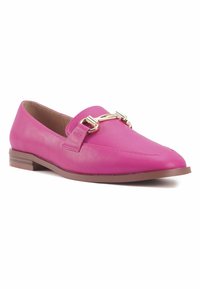 Mocassino in pelle rosa con punta rotonda, dettagli in metallo dorato e suola piatta marrone. Texture liscia con cuciture minime.