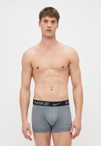Nike muške sive bokserice s crnim elastičnim pojasom s logotipom, prilagođenog dizajna, glatke teksture i do koljena.