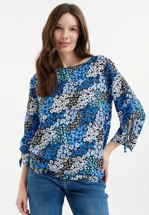 Blaue Blumenbluse mit schwarzem Hintergrund, mit 3/4-Ärmeln, Schleifenakzenten an den Manschetten und einer lässigen Passform.