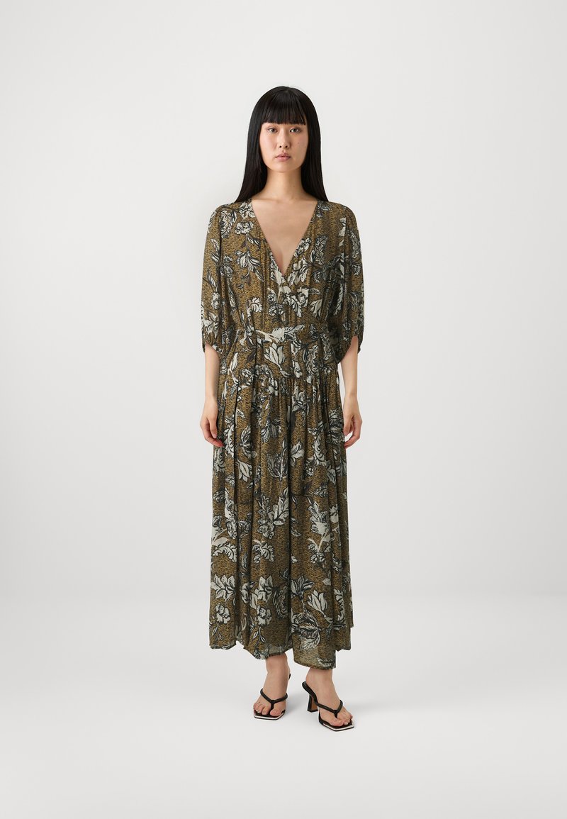 Floral maxi dress in green, with a deep V-neck and puff sleeves. Features a cinched waist, flowing fabric, and a dark floral pattern.