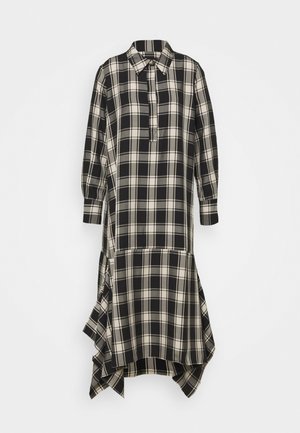 Robe chemise à carreaux noir et blanc avec col, patte de boutonnage à moitié sur le devant, et ourlet asymétrique. Manches longues et tissu doux.