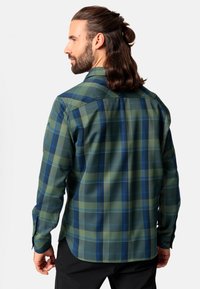 Camisa de franela a cuadros verde y azul con mangas largas, un collar puntiagudo y puños abotonados, que presenta un dobladillo ligeramente redondeado y una textura suave.
