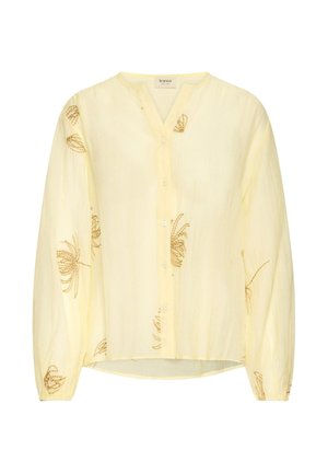 Hele kollane nööpidega pluus pikkade varrukatega ja peene pruuni lillemustriga, mis on kangale hajutatud.