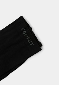 Zwarte legging met een gladde textuur en een elastische tailleband, voorzien van een subtiele grijze logo-opdruk langs de bovenrand. Klassiek ontwerp.