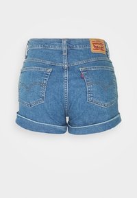 Denim shorts in medium blue, featuring a rolled hem, five pockets, and a leather tag at the back with a logo. Textured fabric.
