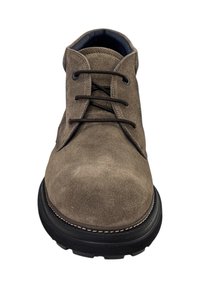 Bruine suède enkelboot met zwarte rubberen zool, vetersluiting aan de voorkant, ronde neus en contrasterende stiksels rond de rand van de zool.