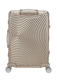 Valigia rigida di colore oro metallico con motivi circolari concentrici, due ruote, maniglia superiore e maniglia laterale per un facile trasporto.