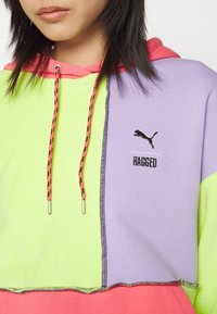 Colorful hoodie featuring sections in neon green, purple, and pink, with a black Puma logo and contrasting drawstring detail.