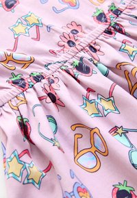 Růžová látka s hravým vzorem květin, slunečních brýlí a jahod, s elastickým stažením podél švu pro texturovaný vzhled.