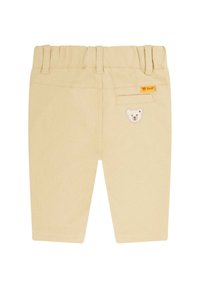 Pantaloni per bambini in cotone beige con vita a coste, una tasca posteriore e un'appliqué di un orsetto ricamato sul lato destro.