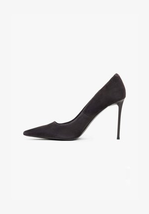 Chaussure à talon haut en daim noir avec un bout pointu, un design épuré et un talon stiletto élancé. Style ouvert sur les côtés mettant en valeur la voûte plantaire.