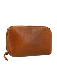 Brown leather zip wallet with a smooth texture, rounded shape, gold-tone zipper, and a small leather tag featuring embossed branding.