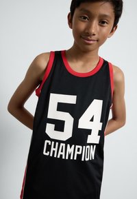 Črna mrežasta košarkaška majica z rdečimi detajli, ki ima velike bele številke "54" in besedo "CHAMPION" v krepkem tisku.