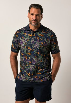 Polo de manga corta en color navy con un patrón floral que presenta hojas verdes y flores naranjas; tejido texturizado con un collar clásico.