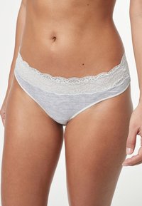 Culottes en coton gris avec une taille en dentelle blanche, présentant une texture douce et une coupe basse pour un ajustement confortable.