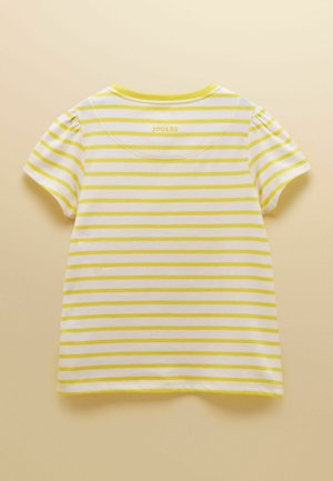 Biała koszulka z krótkim rękawem z żółtymi poziomymi paskami i małym logo „Joules” w pobliżu dekoltu na beżowym tle.