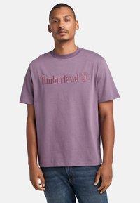 Fialové bavlněné tričko s vyšitým logem "Timberland" a grafikou stromu, krátké rukávy, kulatý výstřih a volný střih.