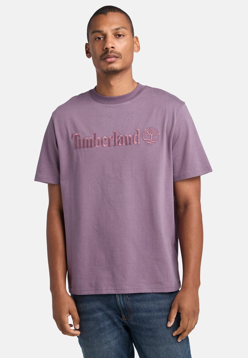 Fialové bavlněné tričko s vyšitým logem "Timberland" a grafikou stromu, krátké rukávy, kulatý výstřih a volný střih.