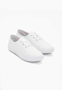 Sneaker bianche in tela con design low-top, chiusura con lacci e occhielli in metallo, e suola in gomma con bordi texturizzati.