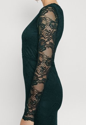 Robe à manches longues de couleur vert foncé, en dentelle florale et tissu texturé, présentant une silhouette ajustée et des détails en dentelle intricats sur les manches.