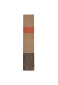 Rectangular rug with horizontal stripes in beige, orange, and brown. Features a ribbed texture and a subtle branding tag at the bottom corner.