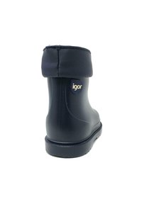 Bota de goma negra impermeable con collar acolchado, forma redondeada, logo en el lateral y suela texturizada para agarre. Ligeramente más ancha en la parte superior.
