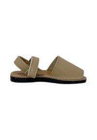 Sandal in pelle beige con punta aperta, cinturino posteriore e suola nera piatta. Presenta un design semplice e cuciture a contrasto lungo i bordi.
