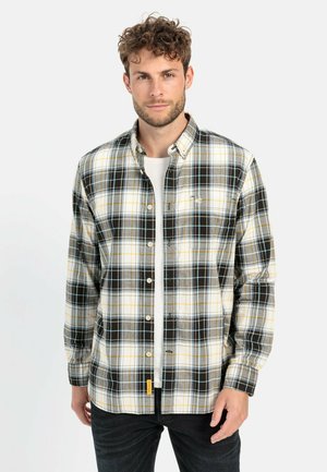 Long-sleeve plaid shirt in black, yellow, and white. Features a button-down collar and a small logo accent. Made of soft fabric.